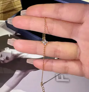 Detail of a sparkling S925 silver four-leaf clover anklet with elegant 18k gold plating.