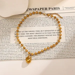 Detailed view of an 18k gold-plated stainless steel beaded necklace with nugget pendant.