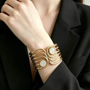 Detailed view of a vintage gold geometric cuff bracelet with white resin stones