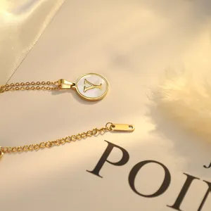 Vue macro détaillée d'un collier lettre Y doré avec un pendentif rond en nacre