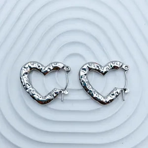 Detailed view of textured silver-tone heart-shaped stainless steel hoop earrings
