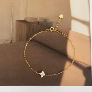 Detailed view of an S925 sterling silver four-leaf clover anklet with 18k gold finish.