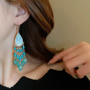 Close-up detail of bohemian style ethnic long tassel drop earrings on a model's ear
