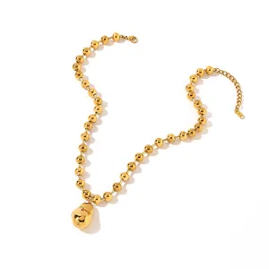 Detailed shot of an 18k gold-plated stainless steel bead necklace with a unique pendant