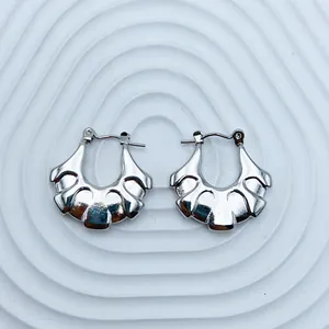 Detailed macro view of silver fan-shaped stainless steel hoop earrings for women