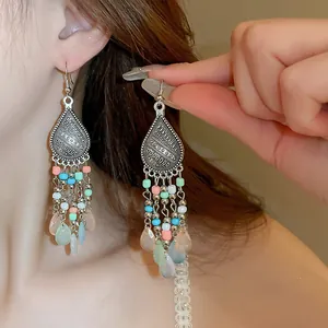 Detail of Bohemian long drop earrings featuring colorful beads and retro silver finish.
