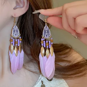 Detail view of Bohemian style long feather hook earrings in elegant purple and gold