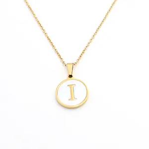 Vue détaillée du pendentif rond doré avec incrustation de nacre blanche et lettre I
