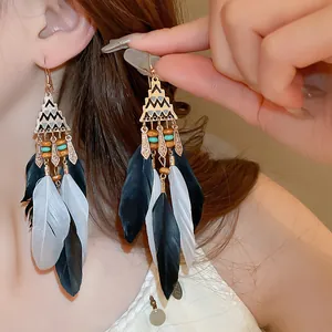 Detailed close-up of Bohemian long feather earrings worn with tribal patterns