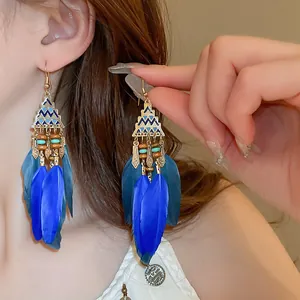 Detailed close-up showing Bohemian blue feather long drop earrings worn by a model.
