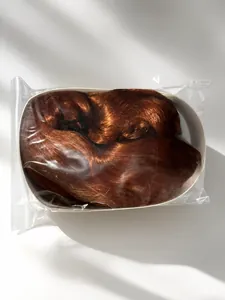 Perruque synthétique longue brun cuivré emballée dans un sac plastique transparent