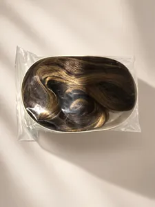 Vue détaillée d'une longue perruque méchée brune dans son emballage plastique