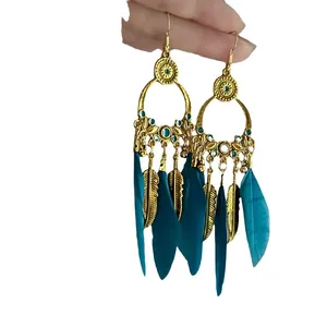 Vintage Bohemian style gold hoop drop earrings featuring teal feathers and leaf charms