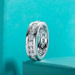 Détail d'une bague éternité en moissanite avec serti rail sur fond turquoise