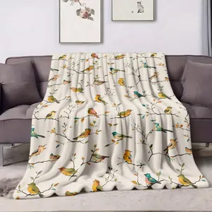 Detailed view of soft throw blanket with vibrant colorful bird pattern on branches