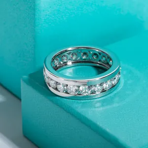 Gros plan d'une bague éternité en moissanite avec pierres sur boîte turquoise.