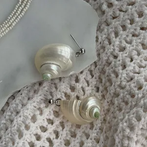 Macro view showing the intricate spiral texture of natural conch shell stud earrings