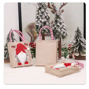 Detailweergave van kerstkabouter jute cadeauzakje met rode polkadot muts en witte baard.
