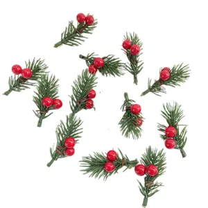 Close-up of small artificial pine sprigs with red berries for Christmas tree decoration