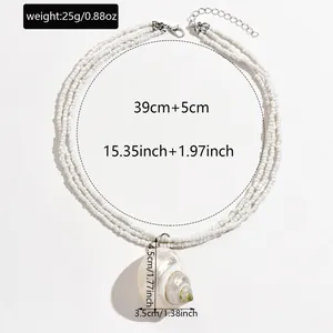 Detailed view of bohemian seed bead necklace with natural shell pendant and measurements