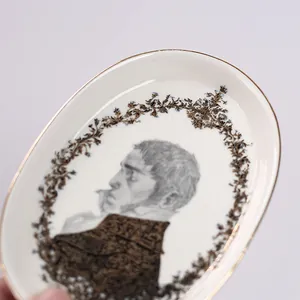 Vue détaillée d'un plateau nordique en céramique avec portrait classique et bordure dorée