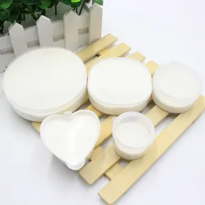 Artificial snow powder in various plastic containers on a wooden tray