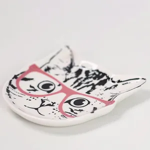 Détail rapproché du plateau à bijoux en céramique visage de chat et lunettes roses