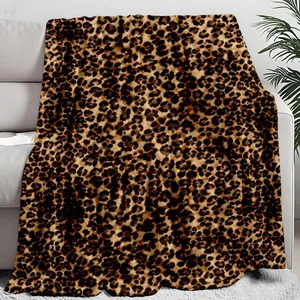 Close-up detail of a soft leopard print plush blanket draped over a minimalist white sofa.