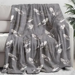 Cozy gray throw blanket with elegant white feather patterns on a sofa