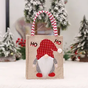 Feestelijke kerstcadeautas van jute met schattig kabouterontwerp en gestreepte handvatten