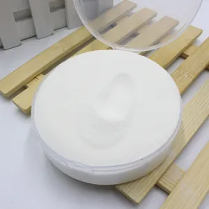 Detailed macro shot of white instant artificial snow powder in a clear round container.