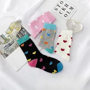 Nahaufnahme von vier bunten Damen-Baumwollsocken mit süßen Herzmustern in verschiedenen Farben