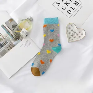 Detailansicht grauer Socken mit bunten Herzmustern und blauen Bündchen