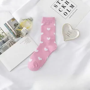 Detaillierte Makroansicht rosa Waden-Socken mit weißen Herzmustern für Damen