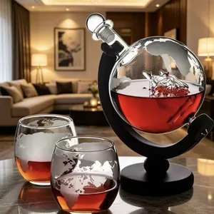 Detail view of globe whiskey decanter set with etched glass and inner sailboat.