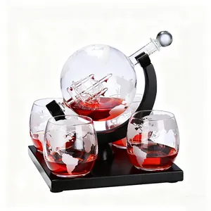 Detailed view of globe whiskey decanter with internal glass ship and etched glasses