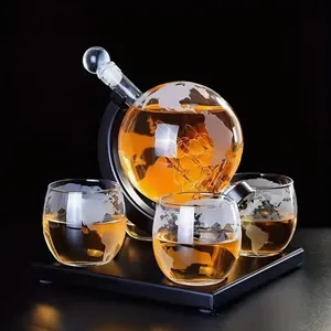 Detailed view of an etched globe whiskey decanter set with three matching glasses