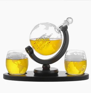 Elegant globe whiskey decanter set with internal glass ship, two glasses and wooden base.