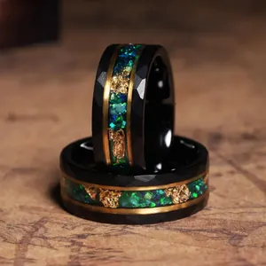 Detail view of black faceted stainless steel rings with green opal and gold foil inlay