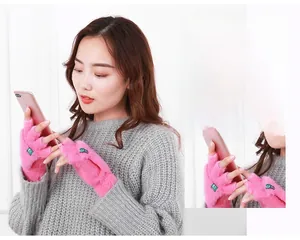 Gants roses en peluche sans doigts avec rabat utilisés sur un smartphone par modèle
