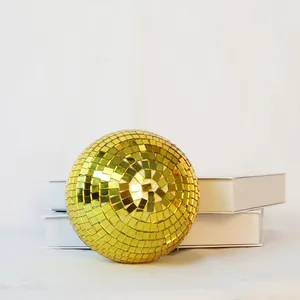Close-up detail of a golden disco mirror ball featuring reflective square mosaic tiles