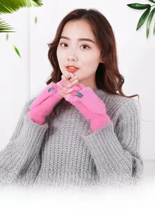 Vue détaillée de mitaines en peluche rose avec rabat portées par un modèle féminin.