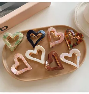 Detailed view of various resin heart-shaped hair claw clips in multiple patterns