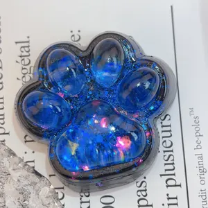 Gros plan d'un jouet antistress en forme de patte de chat bleue étoilée avec paillettes