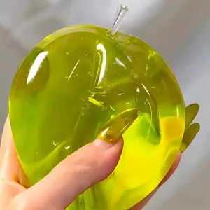 Makroaufnahme eines grünen Squishy-Spielzeugs in Apfelform mit dehnbarer Geltextur
