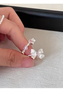 Detalle en primer plano de un anillo de plata S925 con piedras rosa en forma de corazón