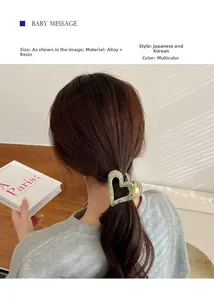 Detail view of a green marble heart-shaped hair claw clip used on tied-back hair