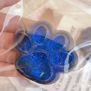 Vue détaillée d'un jouet anti-stress patte de chat pailleté bleu dans son sachet clair