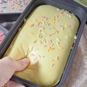 Gros plan d'une main pressant un jouet squishy à rebond lent dans un récipient gris