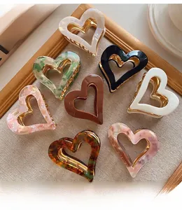 Collection of heart-shaped hair claw clips in assorted vintage colors and patterns